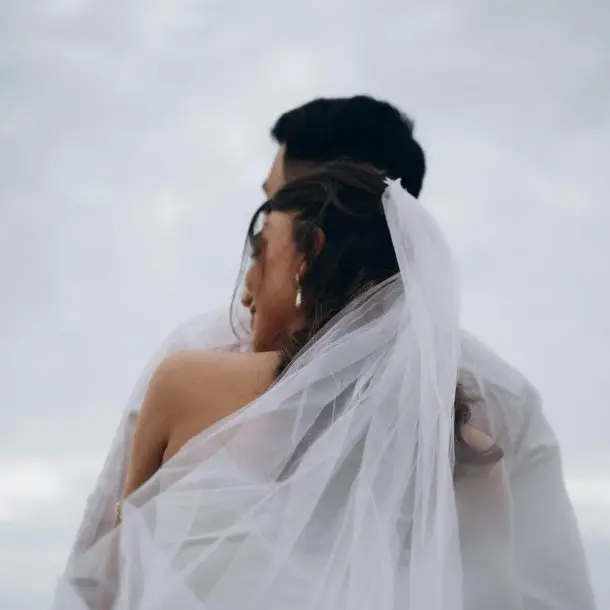 Bride from behind, highlighting the delicate details of her veil