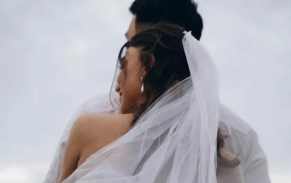 Bride from behind, highlighting the delicate details of her veil