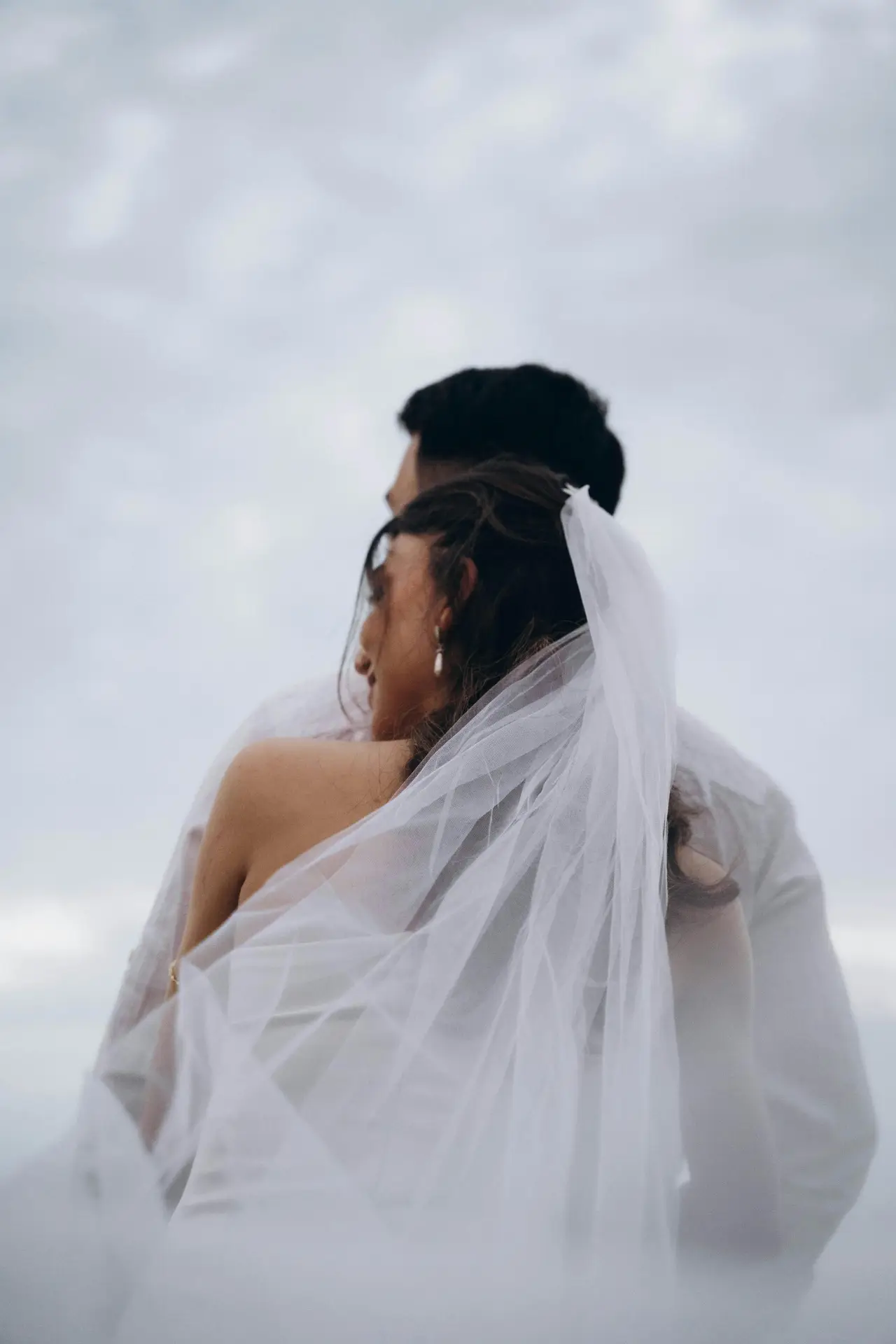 Bride from behind, highlighting the delicate details of her veil