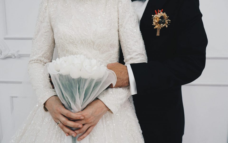 Married couple holding a white tulips bouquet