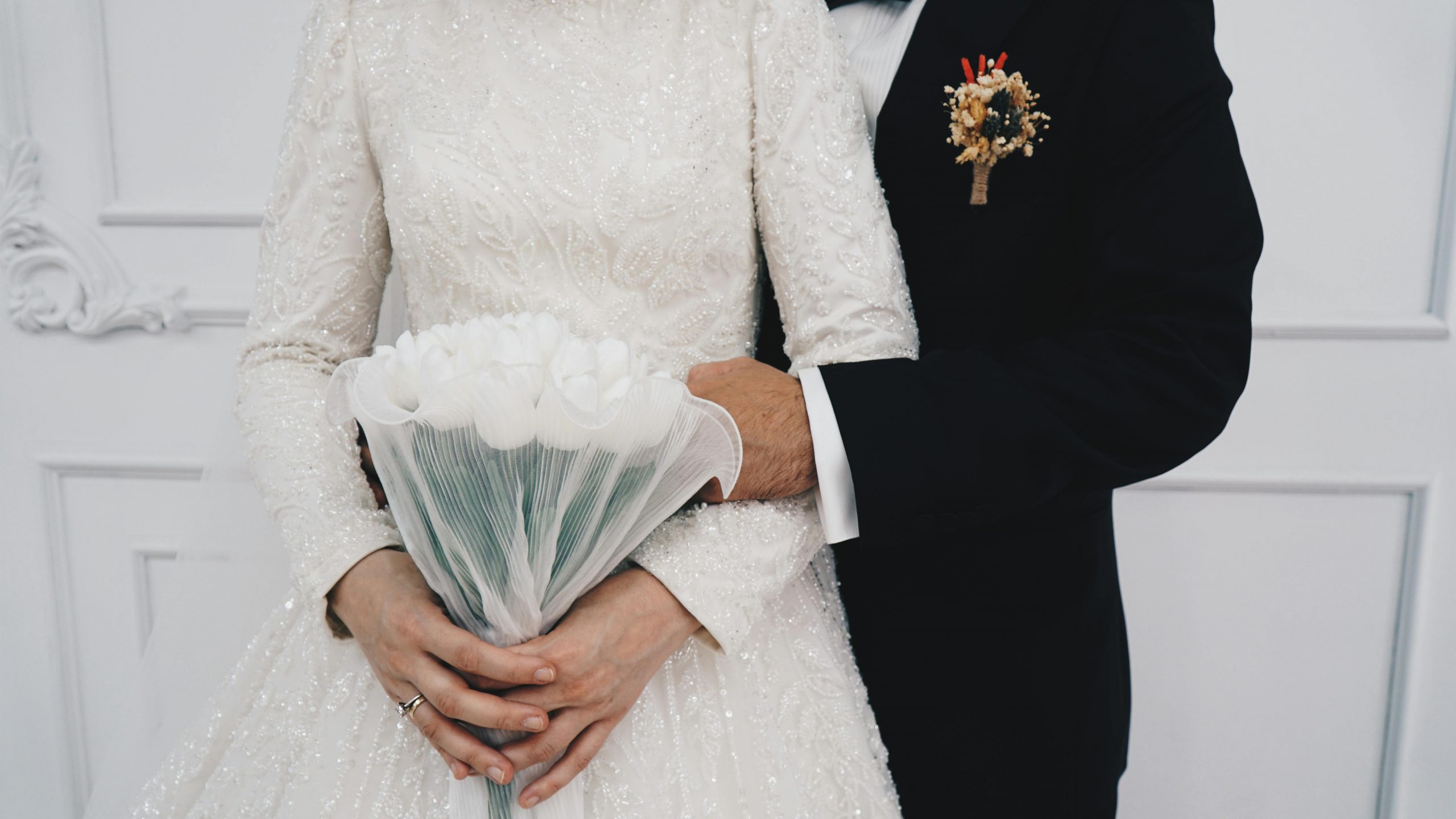 Married couple holding a white tulips bouquet